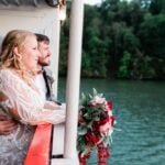 Wedding couple looking out on water from deck of boat
