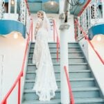 Bride standing on stairs on boat deck looking back
