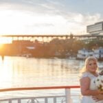 Wedding couple posing on boat deck as sun is setting