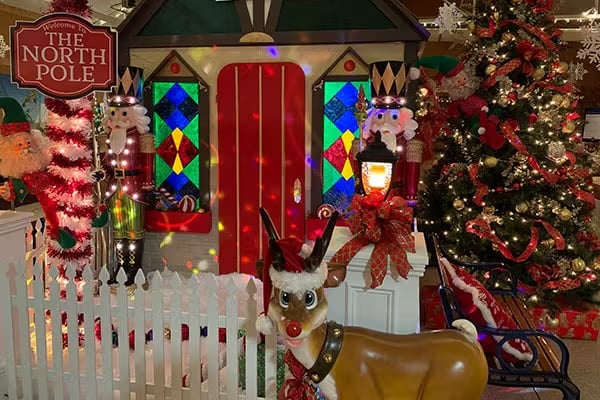 rudolph in front of north pole display